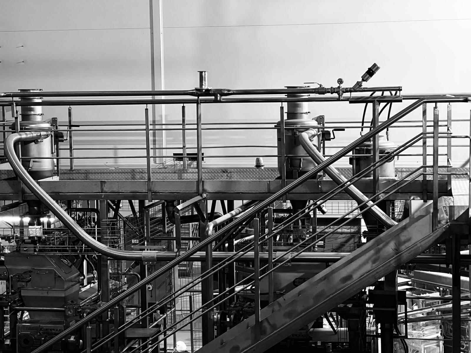 Stainless steel production line with piping and platforms